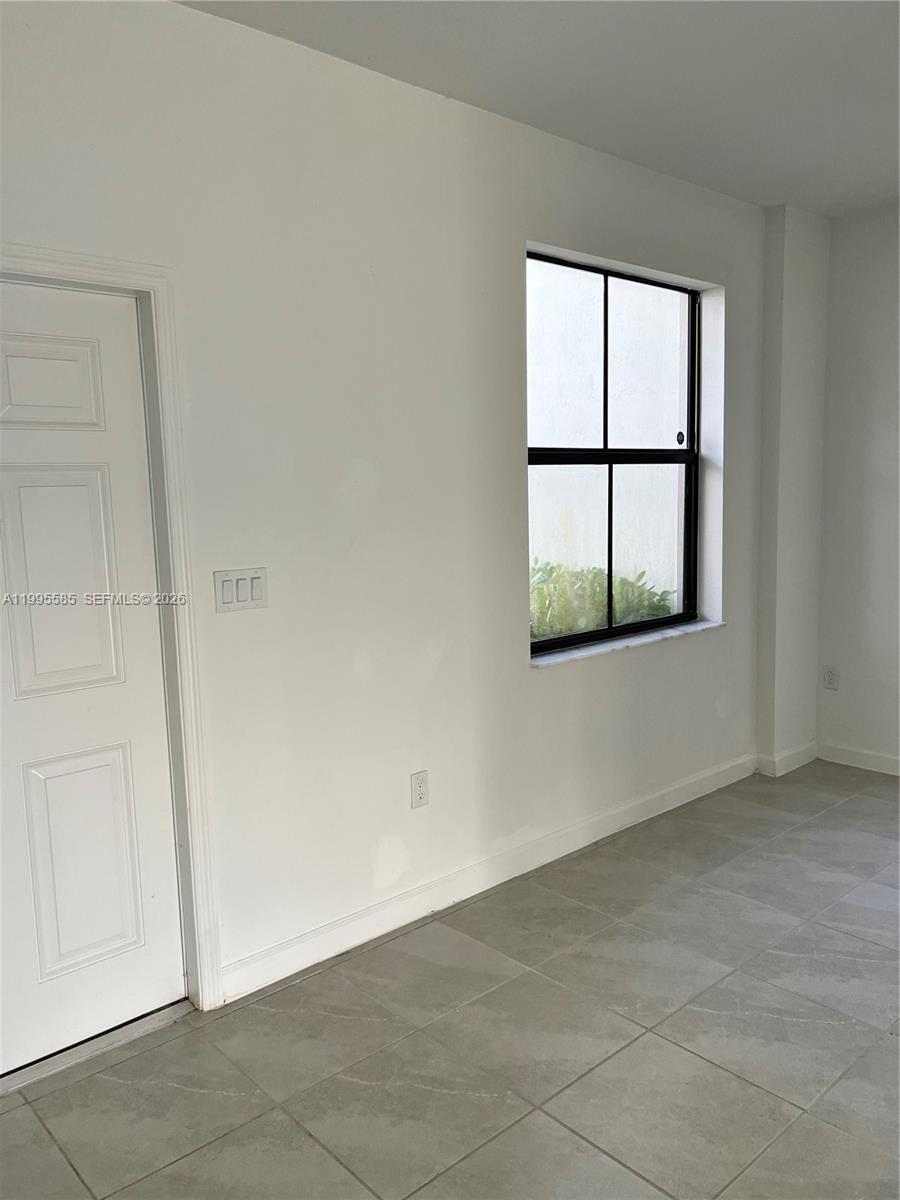 A room with white walls, a single window, a white door, and gray tile flooring — 10030 SW 228th Ter, Miami FL 33190, MIAMI, FL