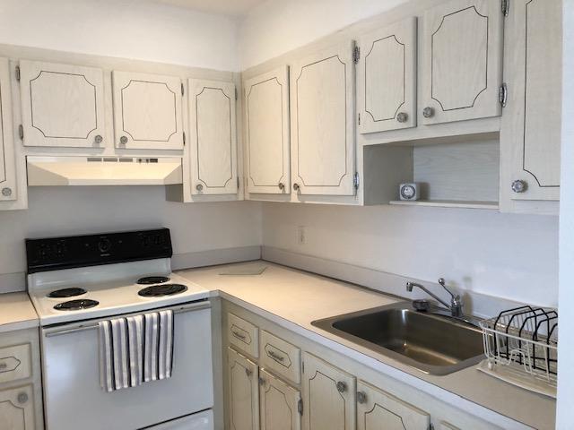 A kitchen with white cabinets, a white electric stove, and a stainless steel sink — 370 Saxony Trail, Delray Beach FL 33446, DELRAY BEACH, FL