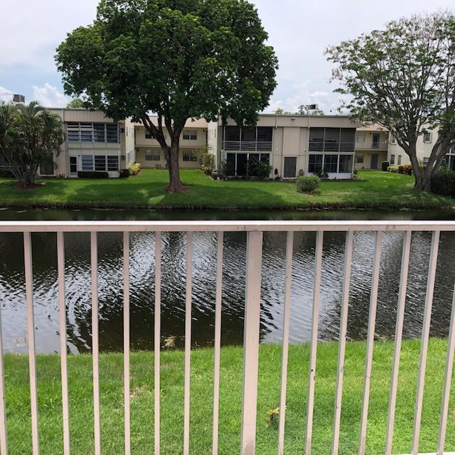 A view of a canal and apartment buildings from a balcony with a white railing — 370 Saxony Trail, Delray Beach FL 33446, DELRAY BEACH, FL