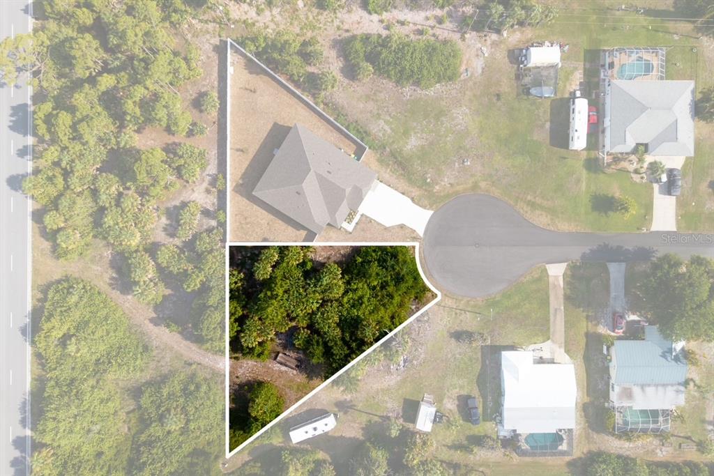 This aerial view shows a triangular wooded lot adjacent to a house and cul-de-sac — 3470 ETHLYN LANE, ROTONDA WEST, FL