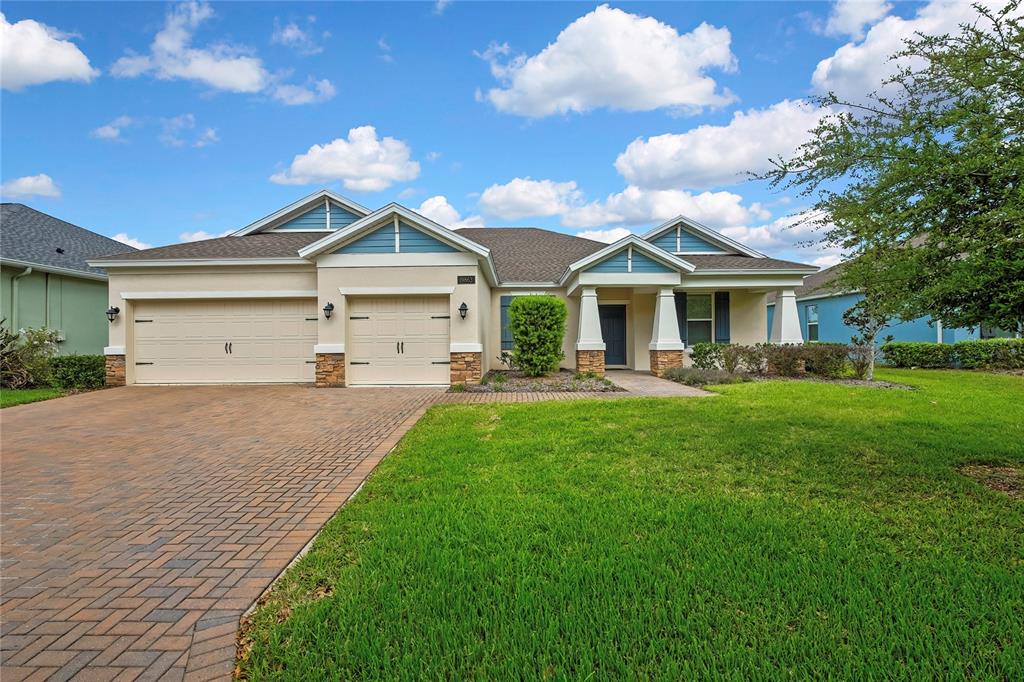 A single-story house with a paved driveway, two-car garage, and a covered front porch — 19863 TATTNALL WAY, BROOKSVILLE, FL