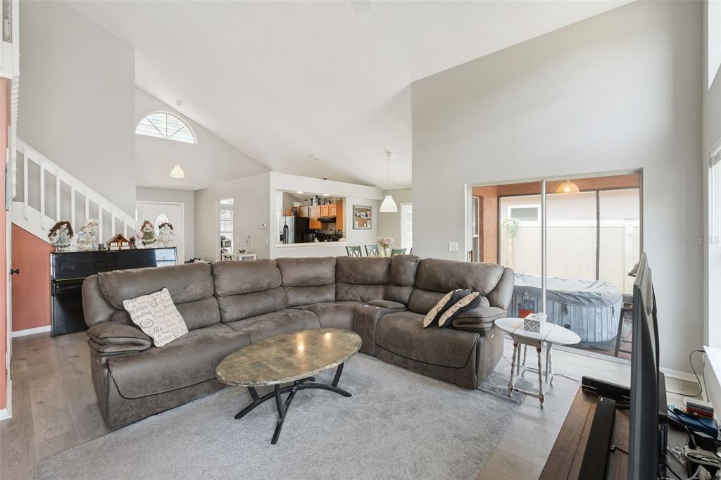 A living room features a large sectional sofa, a coffee table, and a sliding glass door — 4485 WEEPING WILLOW CIRCLE, CASSELBERRY, FL