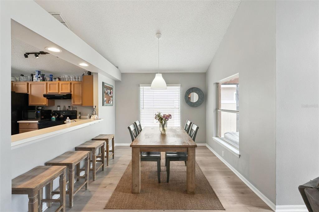 A dining area features a wooden table, chairs, bar stools, and a pendant light fixture — 4485 WEEPING WILLOW CIRCLE, CASSELBERRY, FL