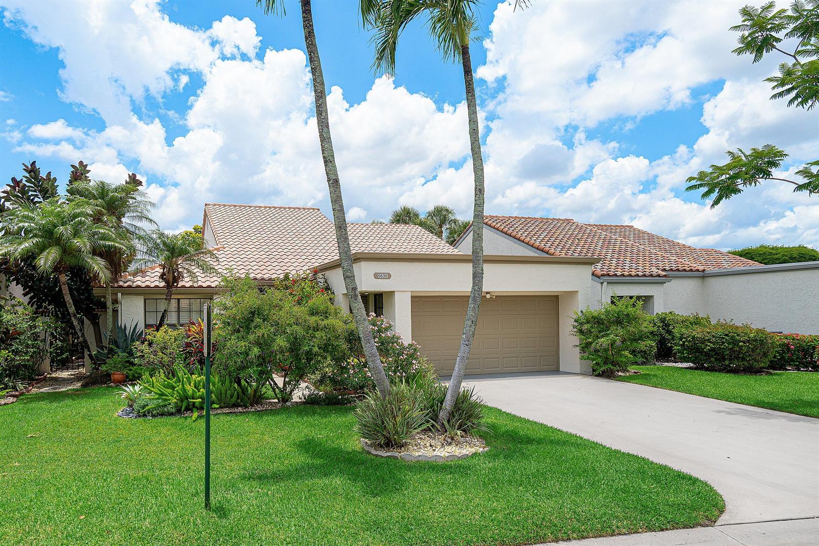 A single-story house with a beige exterior, tile roof, two-car garage, and palm trees — 5635 Kiowa Circle, Boynton Beach FL 33437, BOYNTON BEACH, FL