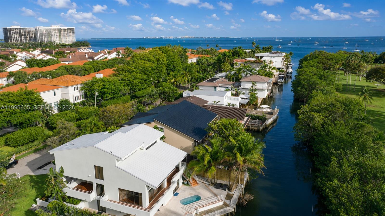 An aerial view shows waterfront houses with pools along a canal leading to the ocean — 3520 Rockerman Rd, Miami FL 33133, MIAMI, FL
