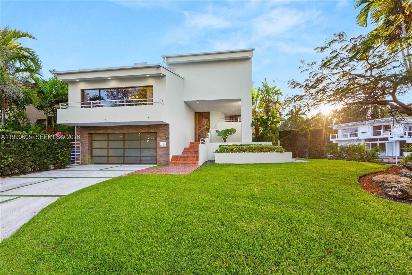 A modern two-story house features a white exterior, a garage, and a front lawn — 3520 Rockerman Rd, Miami FL 33133, MIAMI, FL