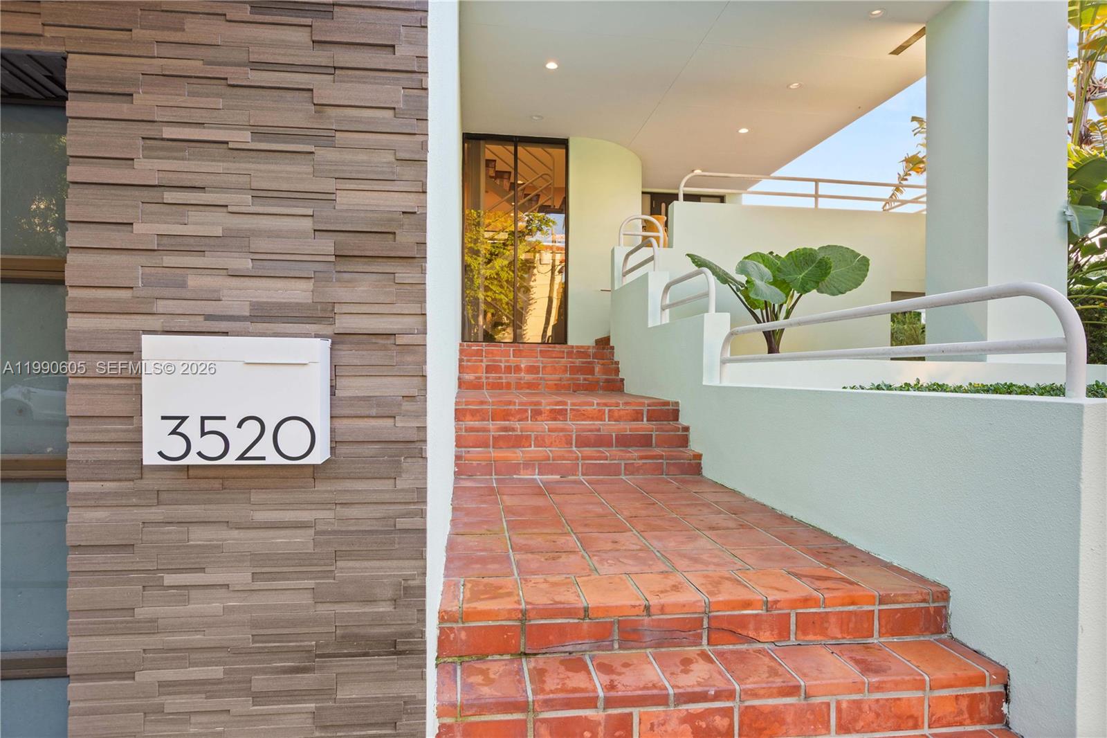 A set of red brick stairs leads to a modern entrance with a house number — 3520 Rockerman Rd, Miami FL 33133, MIAMI, FL