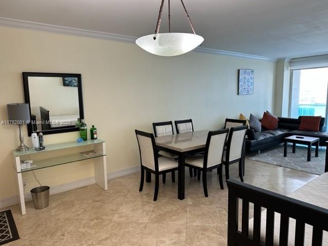 A dining area with a stone-topped table and chairs sits adjacent to a living room — 4001 S Ocean Dr # 9L, Hollywood FL 33019, HOLLYWOOD, FL