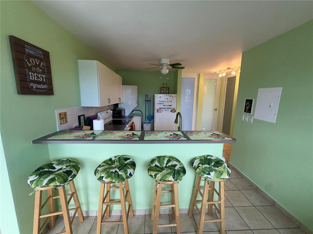 A kitchen features a breakfast bar with four stools and light green walls — 500 CALLE SAN PATRICIO Apt D 402, FAJARDO, PR