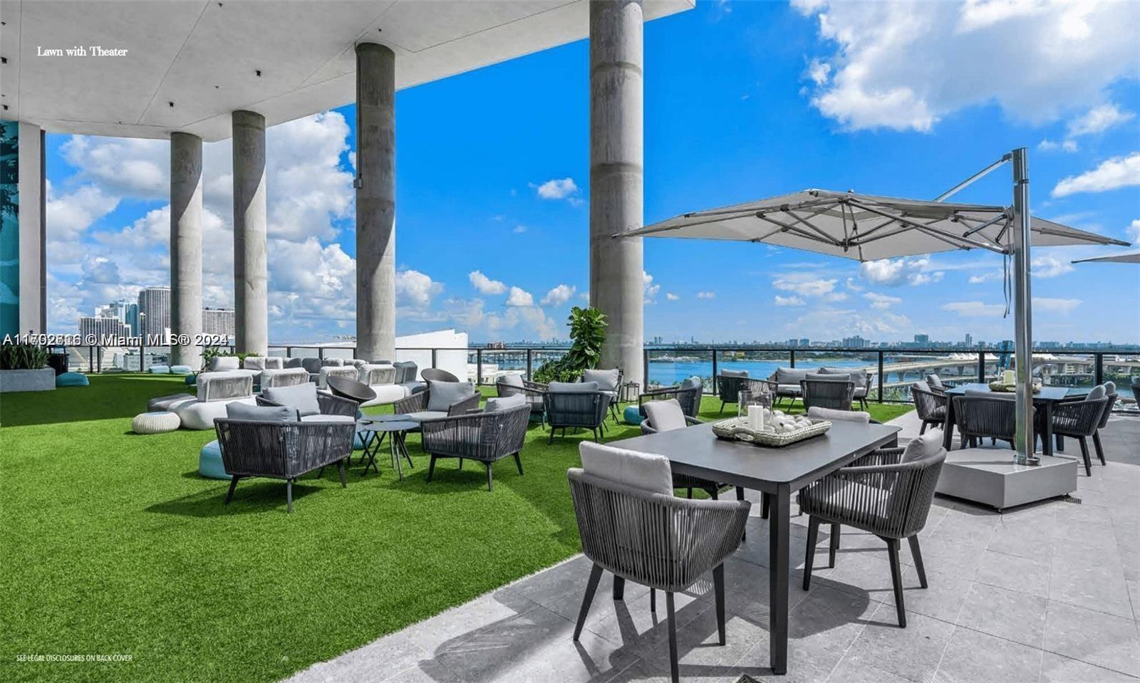 An outdoor rooftop terrace features artificial turf, lounge seating, dining tables, and a large umbrella — 398 NE 5th St # 3010, Miami FL 33132, MIAMI, FL