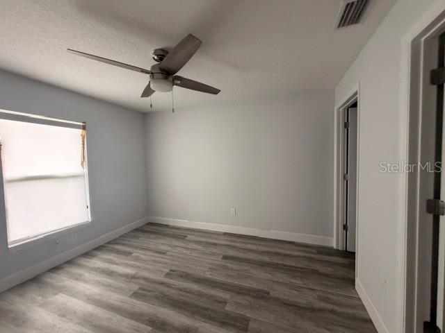 An empty bedroom features light gray walls, wood-look flooring, and a ceiling fan — 3226 SW 152ND COURT, OCALA, FL