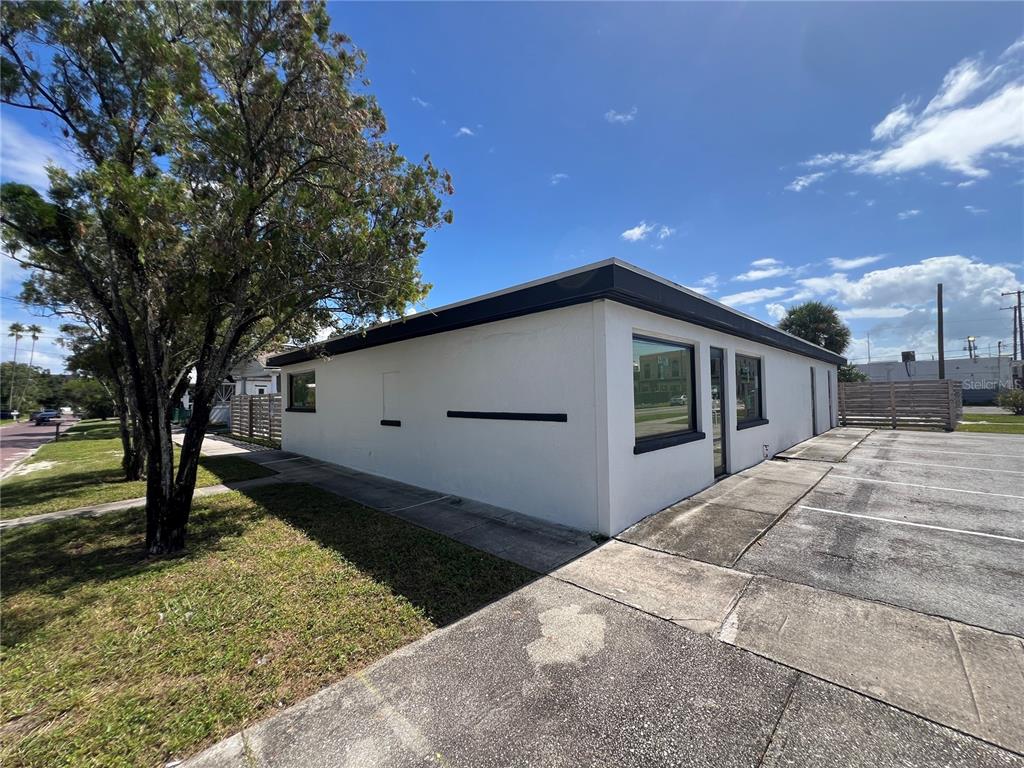 A white, single-story commercial building with a flat roof and adjacent parking lot — 1713 N ALBANY AVENUE, TAMPA, FL