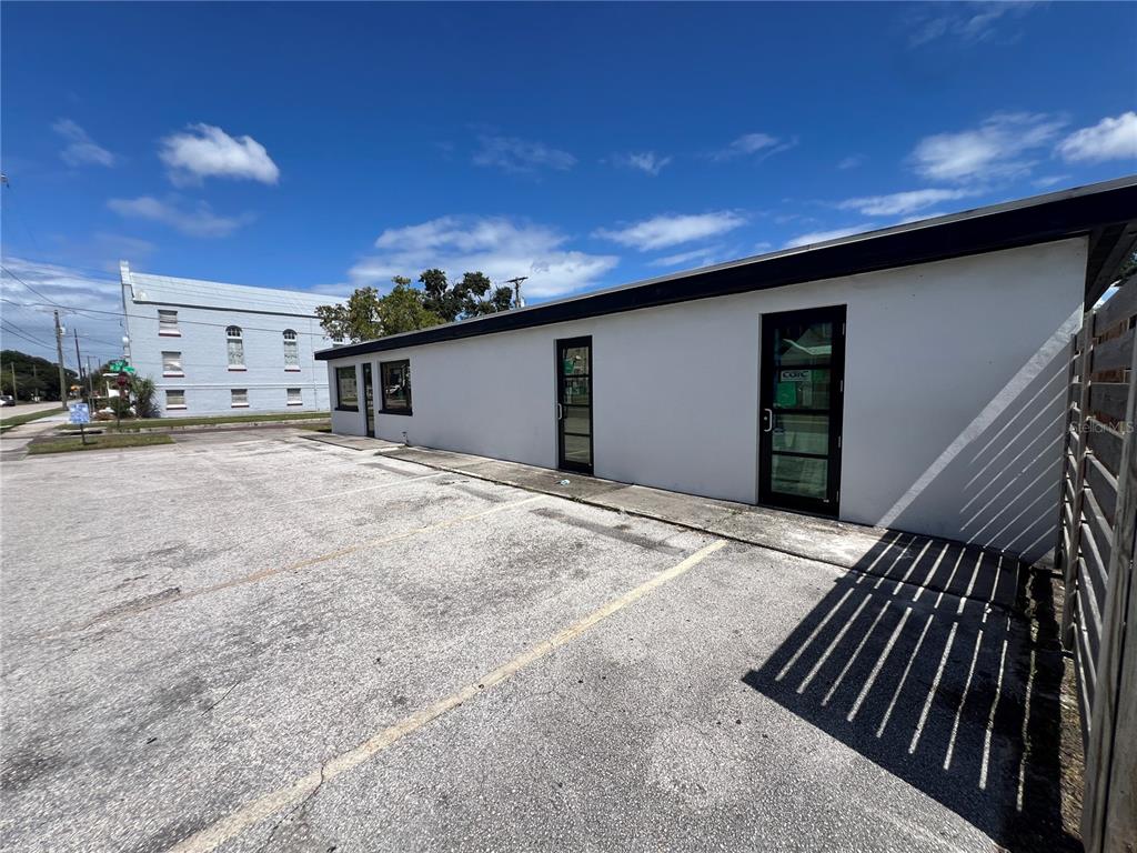 A single-story commercial building with a parking lot and two glass-paneled doors — 1713 N ALBANY AVENUE, TAMPA, FL