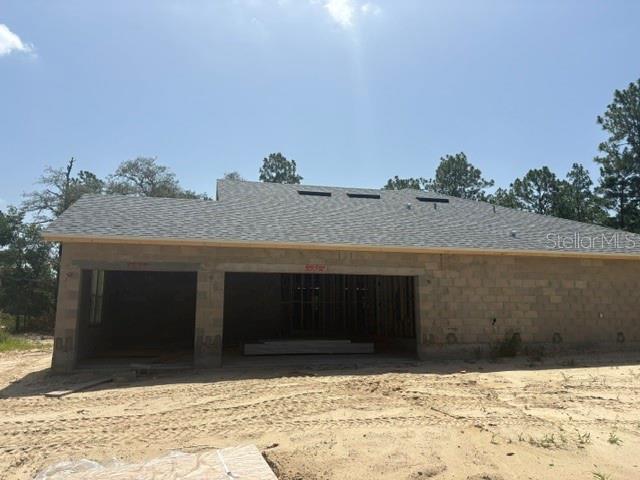 The exterior of a single-story house under construction features concrete block walls and a shingled roof — 12188 SW 81ST STREET, DUNNELLON, FL