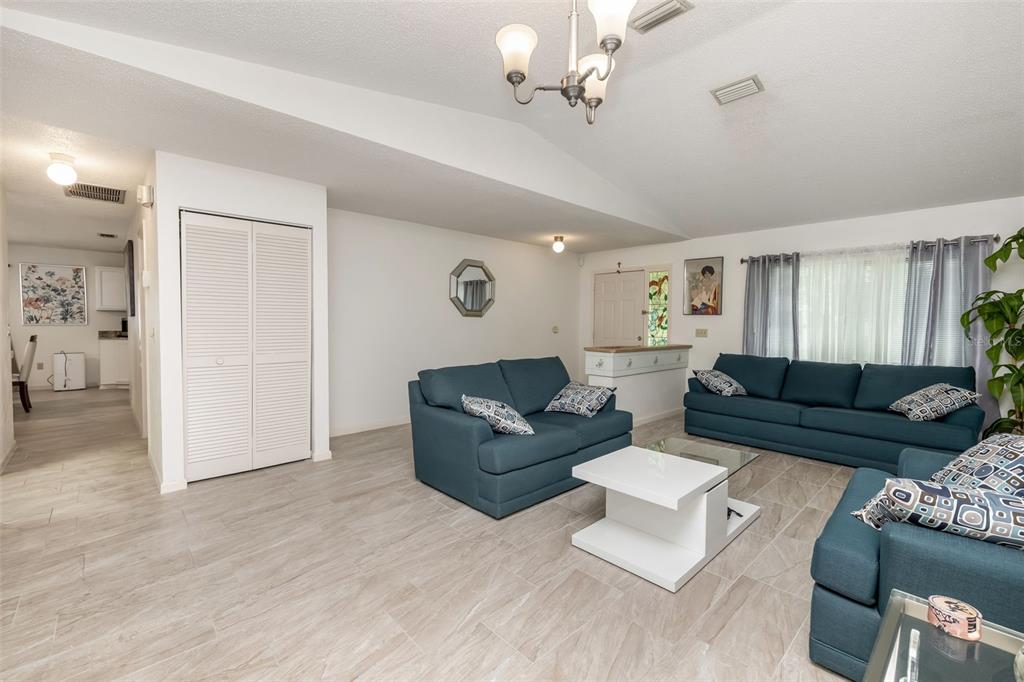 A living room features blue sofas, a white coffee table, and light-colored tile flooring — 7 PERKINS LANE, PALM COAST, FL