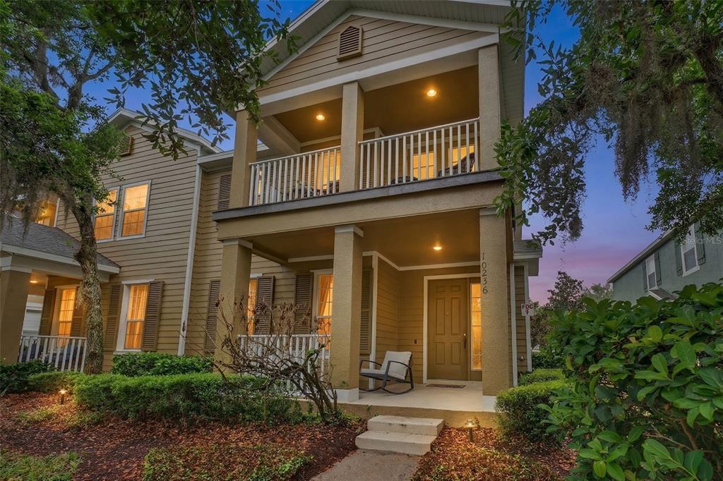 A two-story house with tan siding, a front porch, and a second-story balcony — 10236 LAKE DISTRICT LANE UNIT 35C, ORLANDO, FL