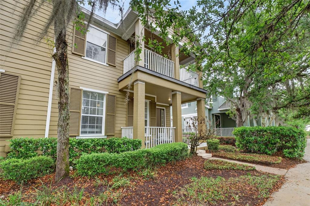 A two-story house with tan siding, a front porch, and a second-floor balcony — 10236 LAKE DISTRICT LANE UNIT 35C, ORLANDO, FL