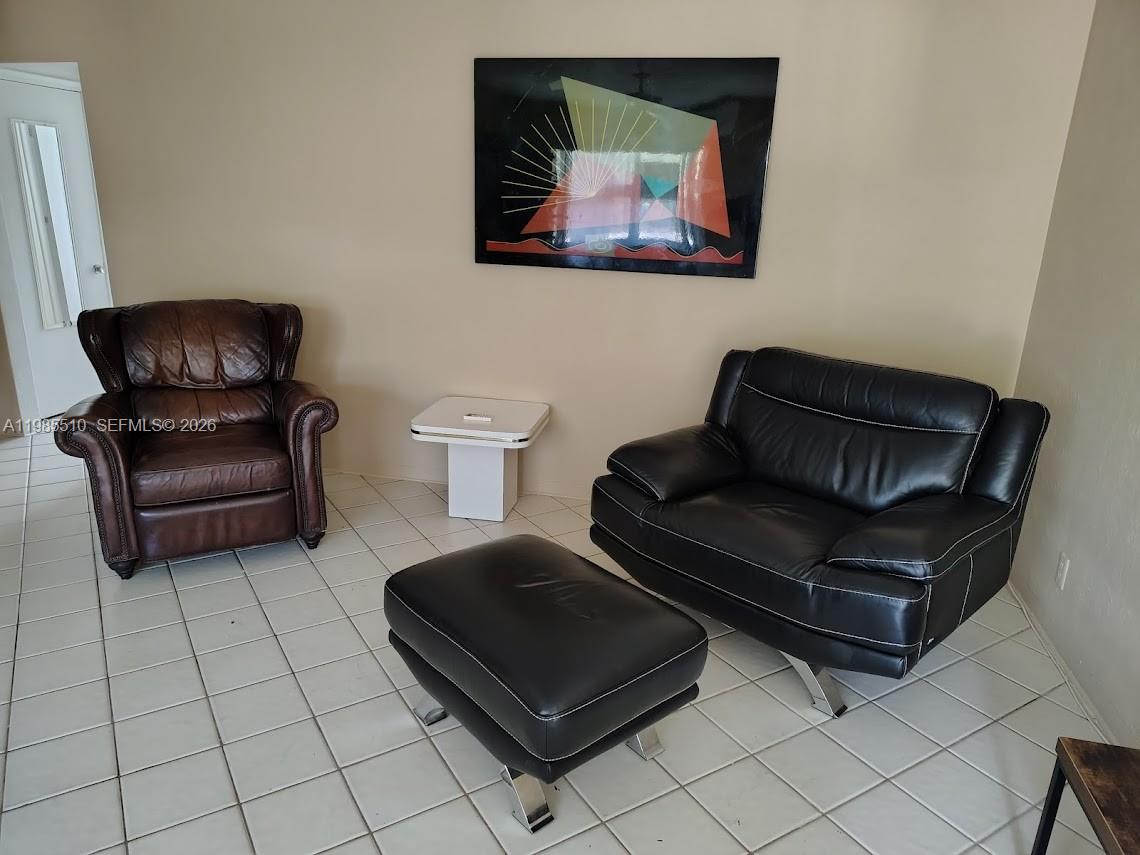 A living room features a brown leather armchair, a black leather chair with ottoman, and artwork — 1816 Mckinley St # 2, Hollywood FL 33020, HOLLYWOOD, FL