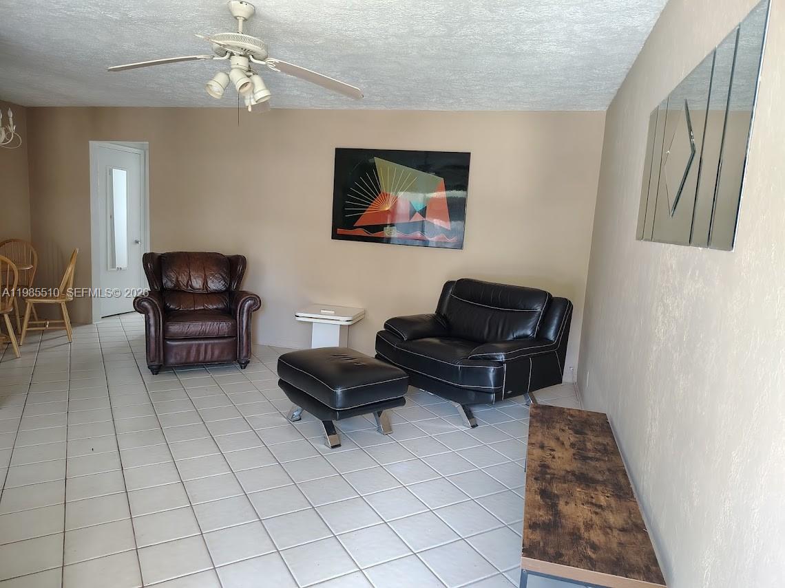 A living room features tiled floors, a ceiling fan, and two leather armchairs with ottoman — 1816 Mckinley St # 2, Hollywood FL 33020, HOLLYWOOD, FL