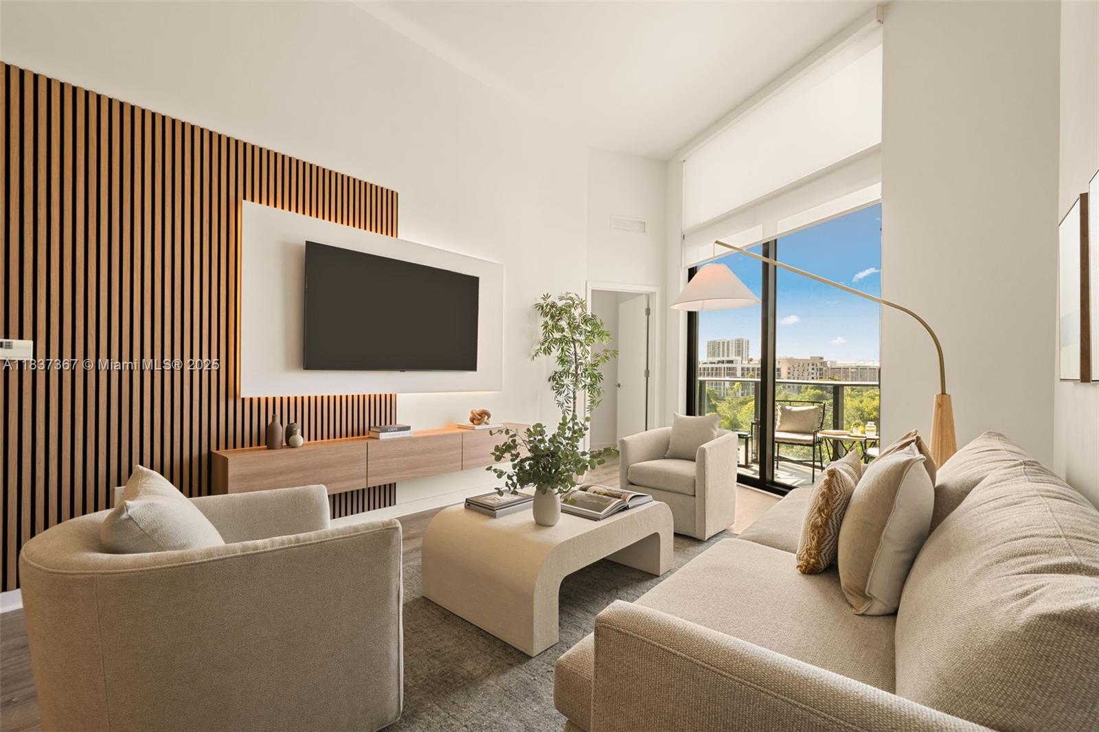 A modern living room features a slatted wood accent wall, a wall-mounted television, and balcony access — 501 NE 31st St # 410, Miami FL 33137, MIAMI, FL