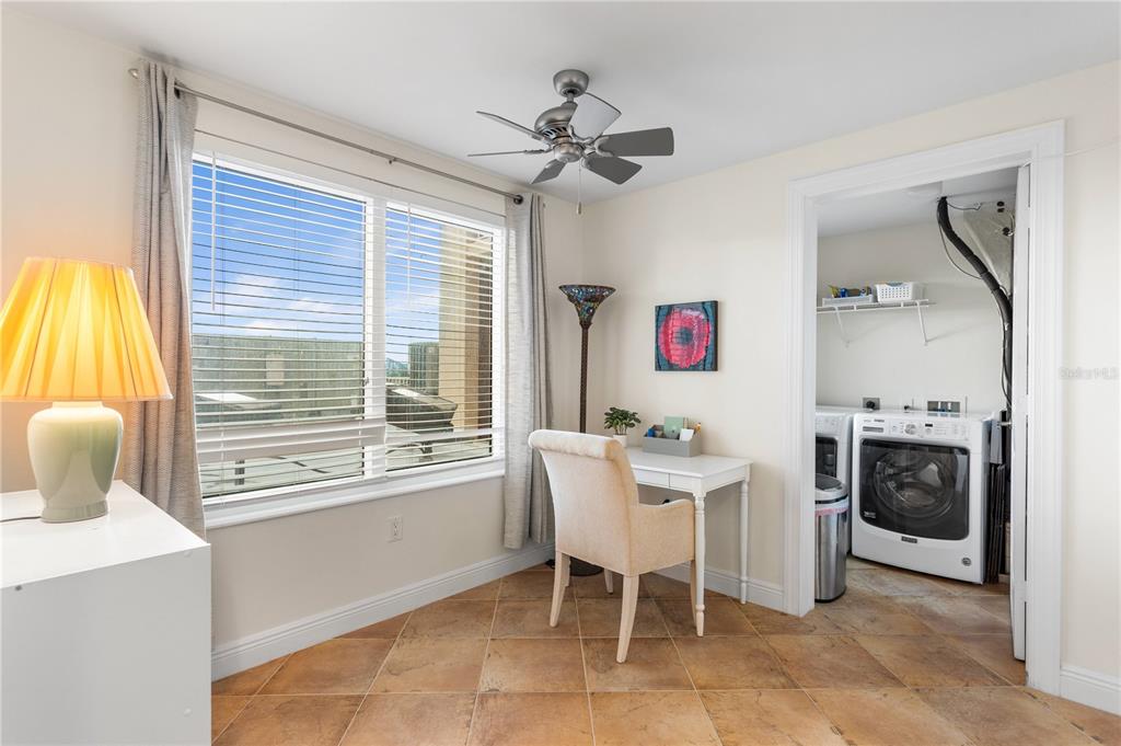 A room with tile floors, a desk, a window, and an adjacent laundry closet — 2743 1ST STREET UNIT 406, FORT MYERS, FL