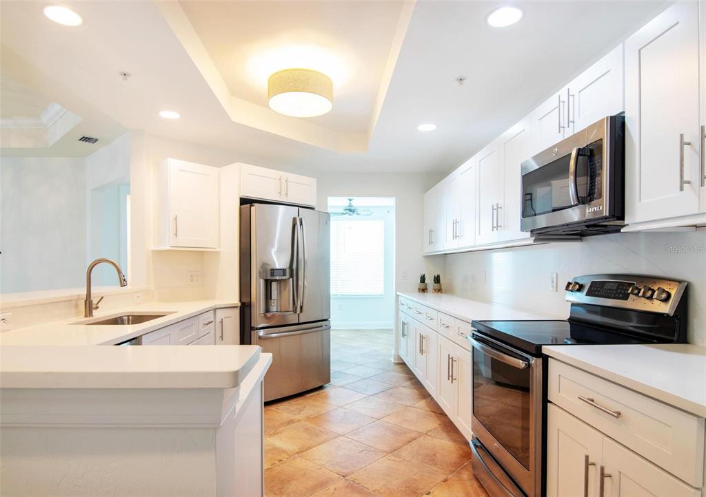 A kitchen with white cabinets, stainless steel appliances, and tile flooring — 2743 1ST STREET UNIT 406, FORT MYERS, FL