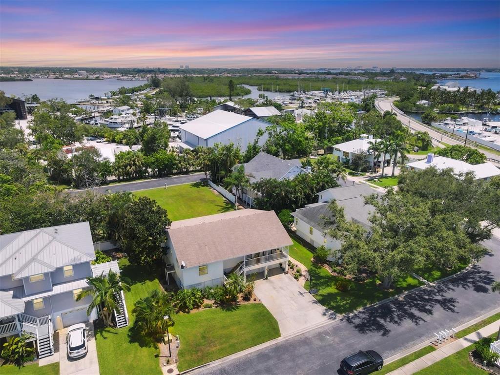 An aerial view shows a two-story house with a driveway near a marina and water — 1408 43RD AVENUE DRIVE W, PALMETTO, FL