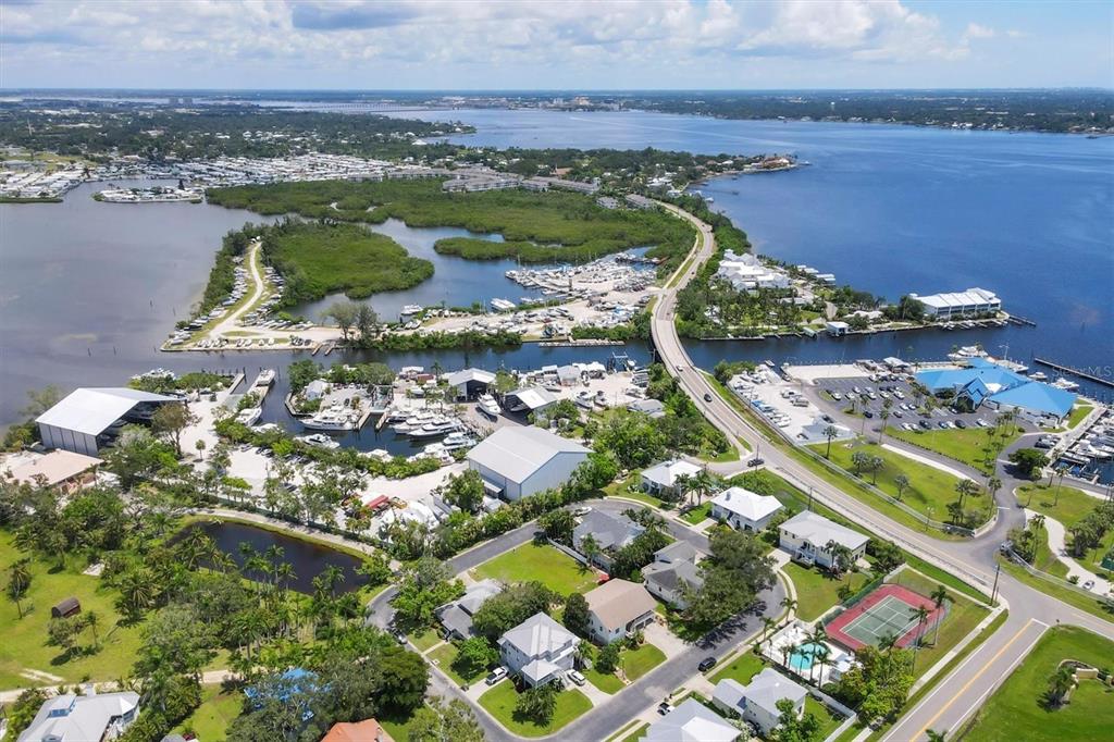 An aerial view shows a coastal marina, a bridge, and surrounding residential properties near water — 1408 43RD AVENUE DRIVE W, PALMETTO, FL