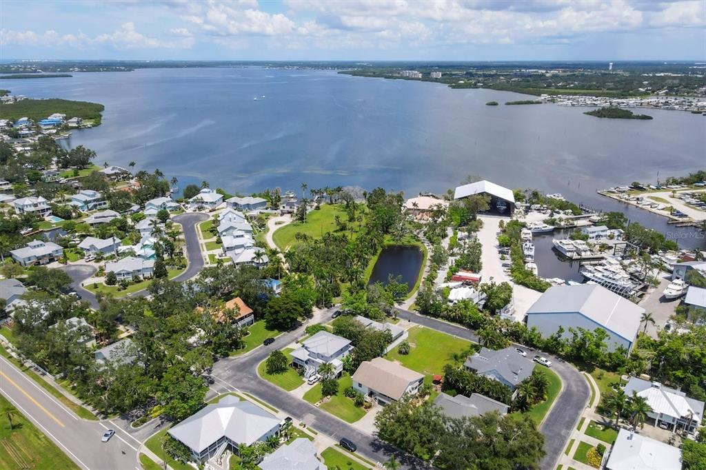 An aerial view shows a coastal residential neighborhood with a marina and a large bay — 1408 43RD AVENUE DRIVE W, PALMETTO, FL