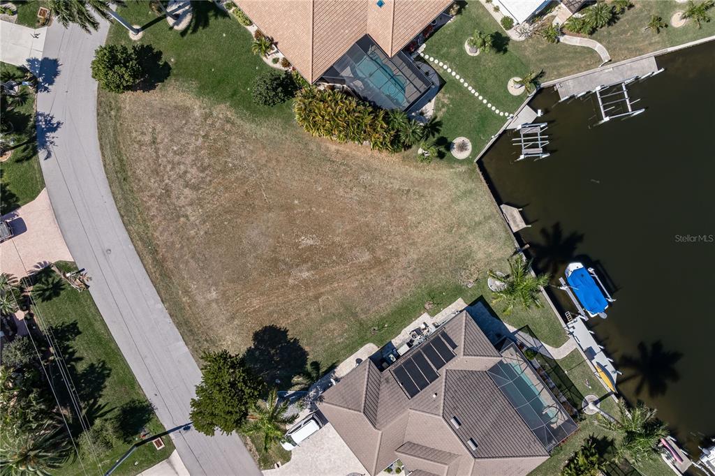 An aerial view shows a vacant waterfront residential lot situated between two existing houses — 5045 SAN MASSIMO DRIVE, PUNTA GORDA, FL