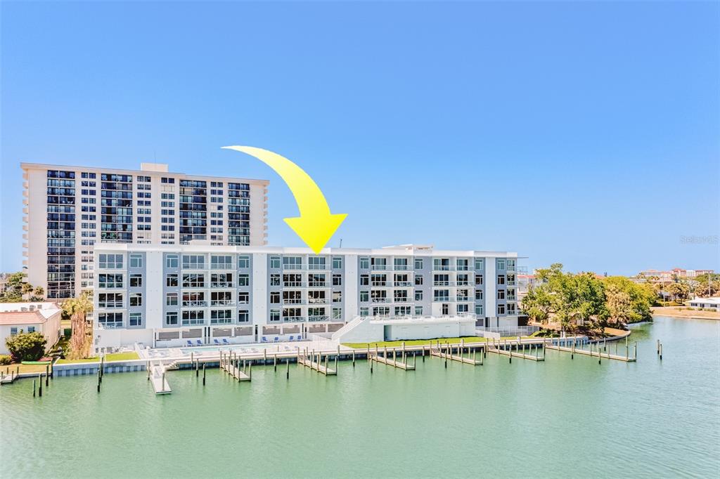 An exterior view of a multi-story waterfront condominium building with boat docks — 415 ISLAND WAY UNIT 505, CLEARWATER, FL