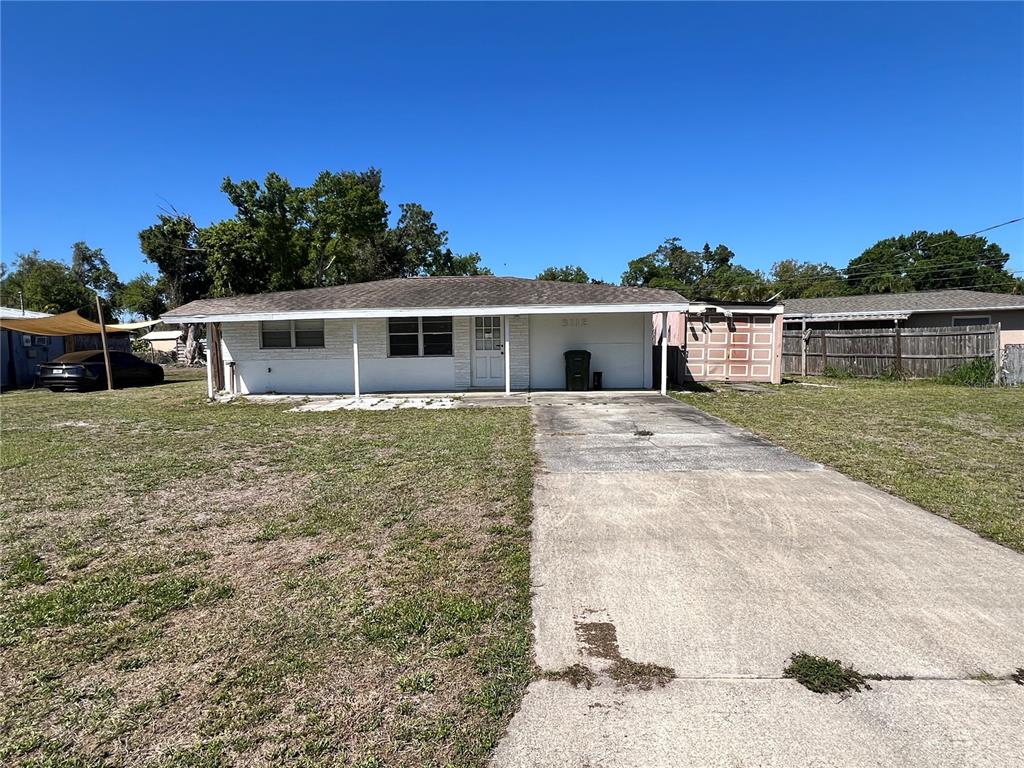 A single-story house with a white exterior, a concrete driveway, and a detached storage shed — 3112 SAVOY WAY, SARASOTA, FL