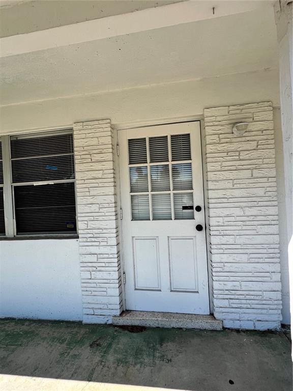 A white door with glass panes is flanked by white brick columns on a porch — 3112 SAVOY WAY, SARASOTA, FL