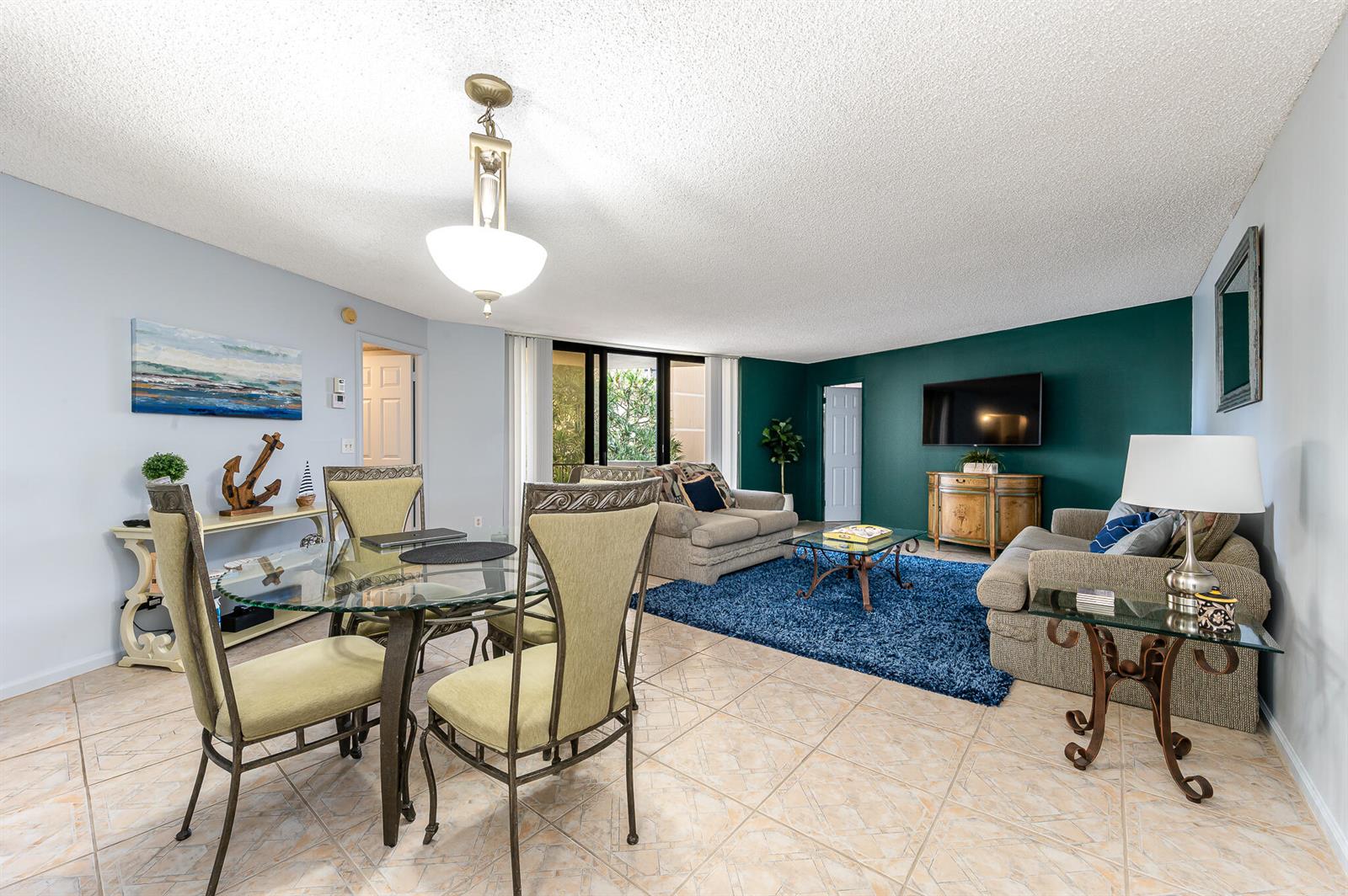 A living and dining area features tile floors, a dark green accent wall, and furniture — 2800 N Ocean Drive # 2b, Singer Island FL 33404, SINGER ISLAND, FL