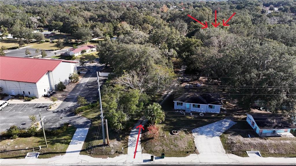 An aerial view shows a residential lot with a house, driveway, and surrounding trees — ORANGE STREET, LADY LAKE, FL