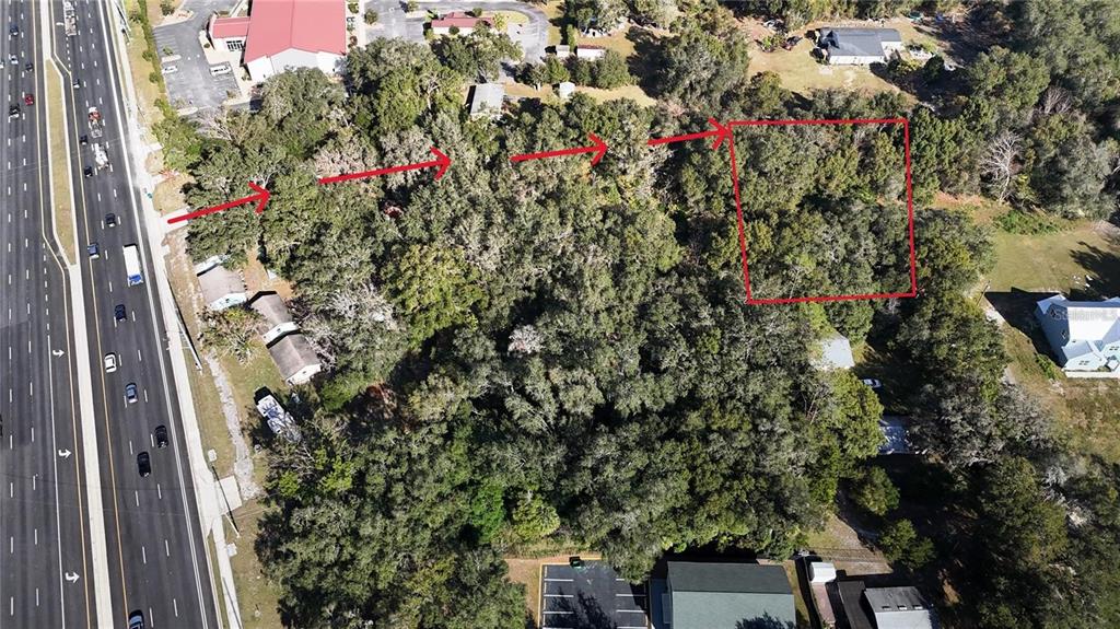 An aerial view shows a wooded lot with red arrows and a red boundary box — ORANGE STREET, LADY LAKE, FL