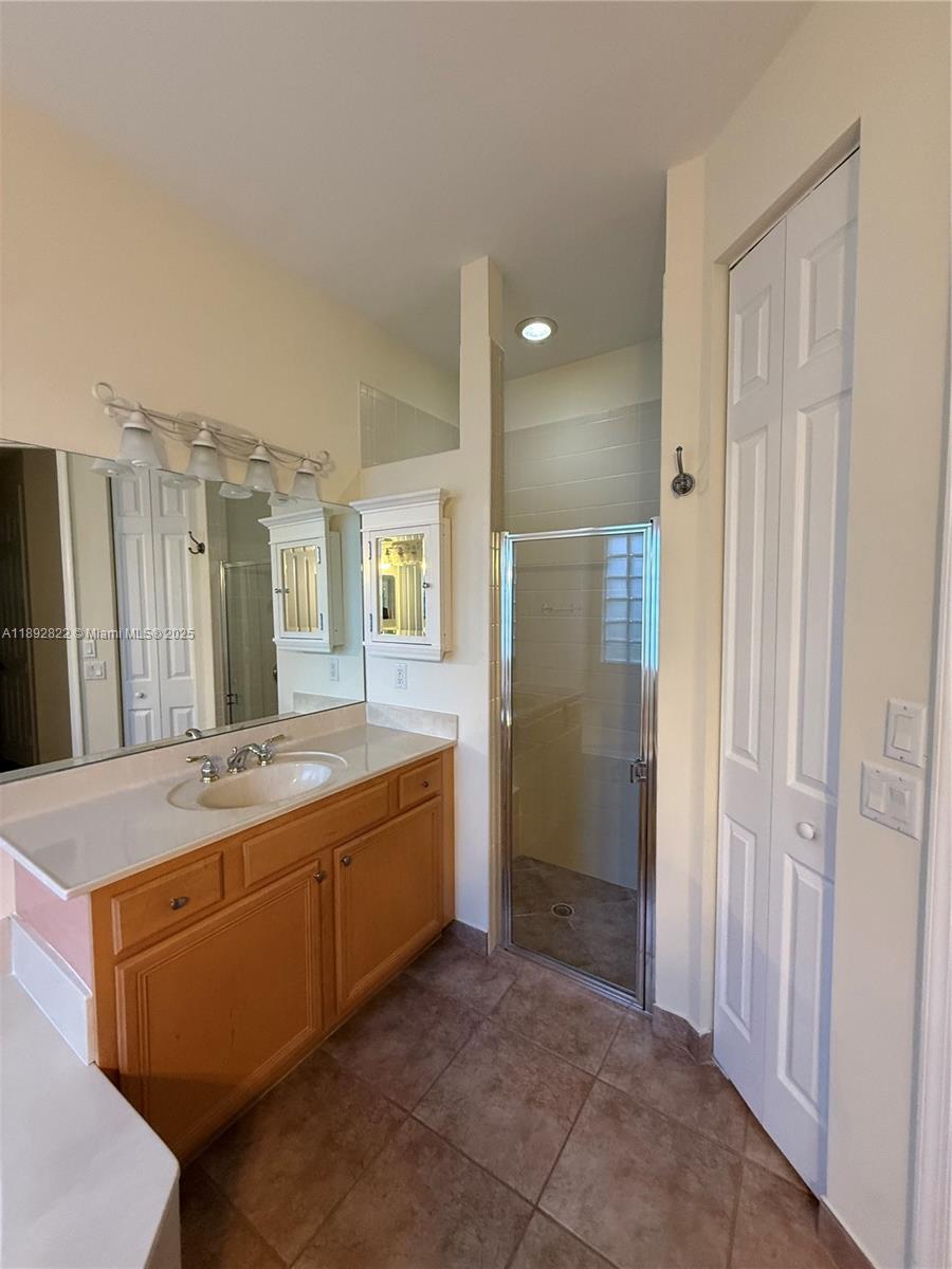 A bathroom features a wooden vanity, a glass-enclosed shower, and a large wall mirror — 6683 Southport Dr, Boynton Beach FL 33472, BOYNTON BEACH, FL