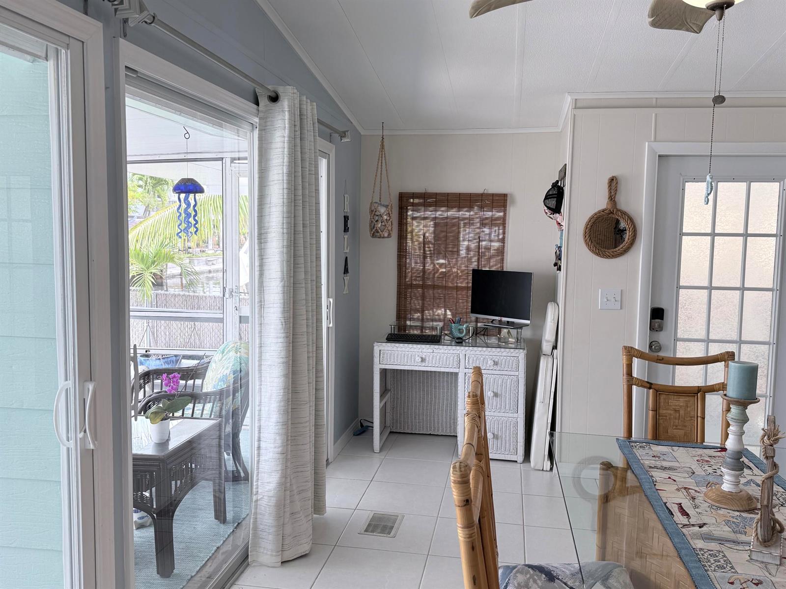 A bright room features a white wicker desk, tile flooring, and a sliding glass door — 225 W 2nd Court, Key Largo FL 33037, KEY LARGO, FL
