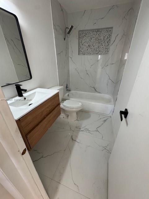 A modern bathroom features a wood vanity, a white toilet, and a marble-tiled tub enclosure — 3840 NE 12th Ave, Pompano Beach FL 33064, POMPANO BEACH, FL