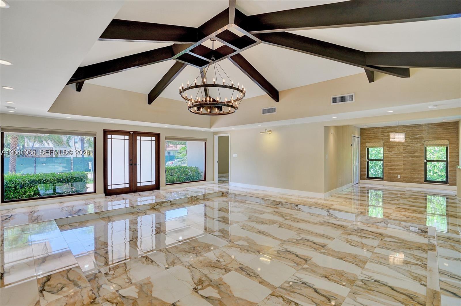 A spacious room features a vaulted ceiling with dark beams, a chandelier, and marble flooring — 2255 NE 120th St, North Miami FL 33181, NORTH MIAMI, FL