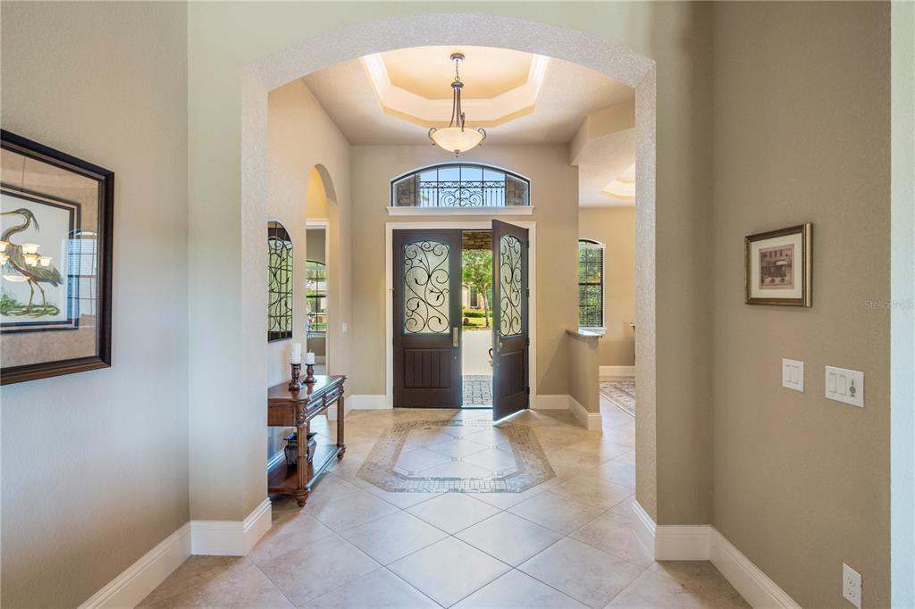An entryway features a tiled floor, a double-door entrance, and an arched ceiling transition — 11753 VINCI DRIVE, WINDERMERE, FL