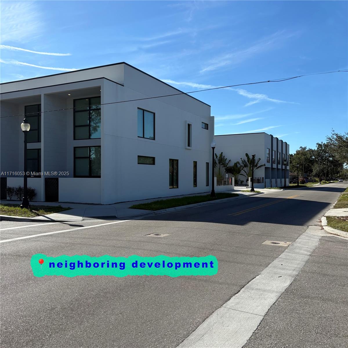 Two modern, white multi-story buildings stand on a paved street under a clear blue sky — 1744 10th st, Sarasota FL 34236, SARASOTA, FL