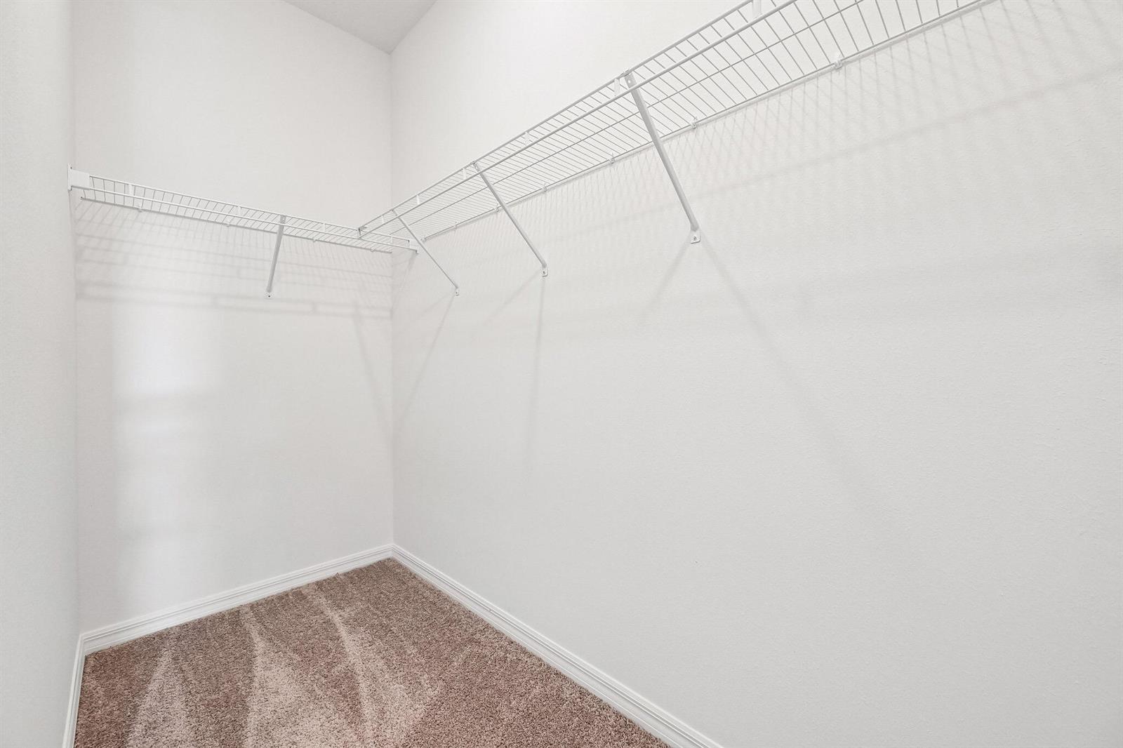 A walk-in closet with white walls, beige carpeting, and white wire shelving — 5200 Hickory Drive, Fort Pierce FL 34982, FORT PIERCE, FL