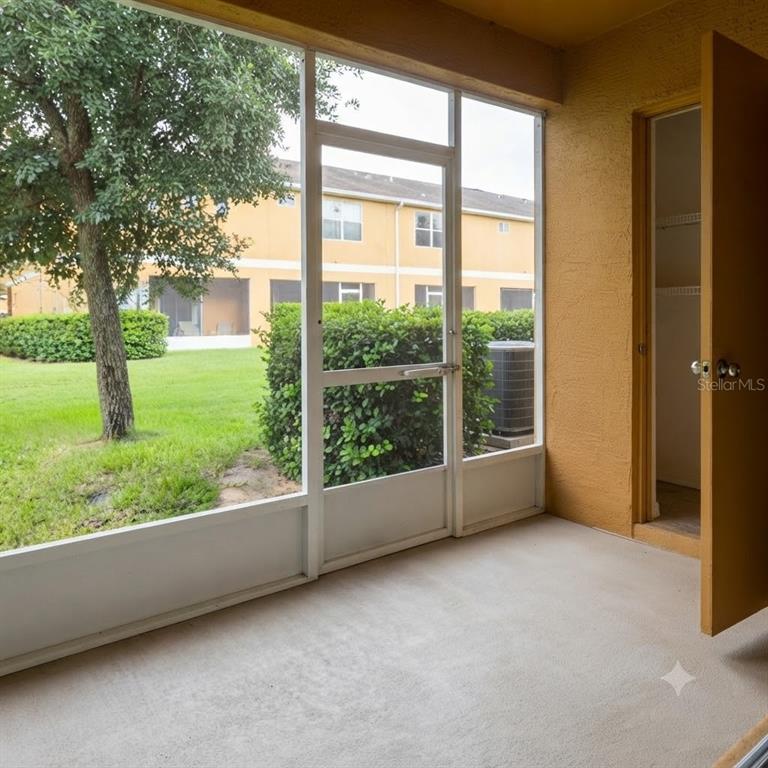 A screened-in patio with a concrete floor and an open storage closet door — 1561 CHELSEA DRIVE, DAVENPORT, FL
