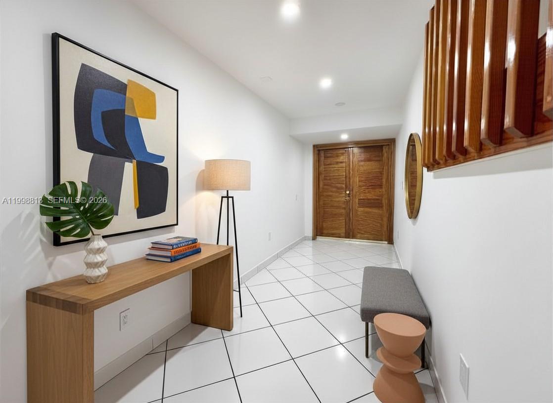 A modern entryway features white tiled floors, a wooden console table, and abstract wall art — 10140 SW 26th Ter, Miami FL 33165, MIAMI, FL