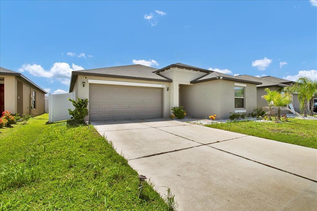 A single-story house with a beige exterior, a two-car garage, and a concrete driveway — 769 CALICO SCALLOP STREET, RUSKIN, FL