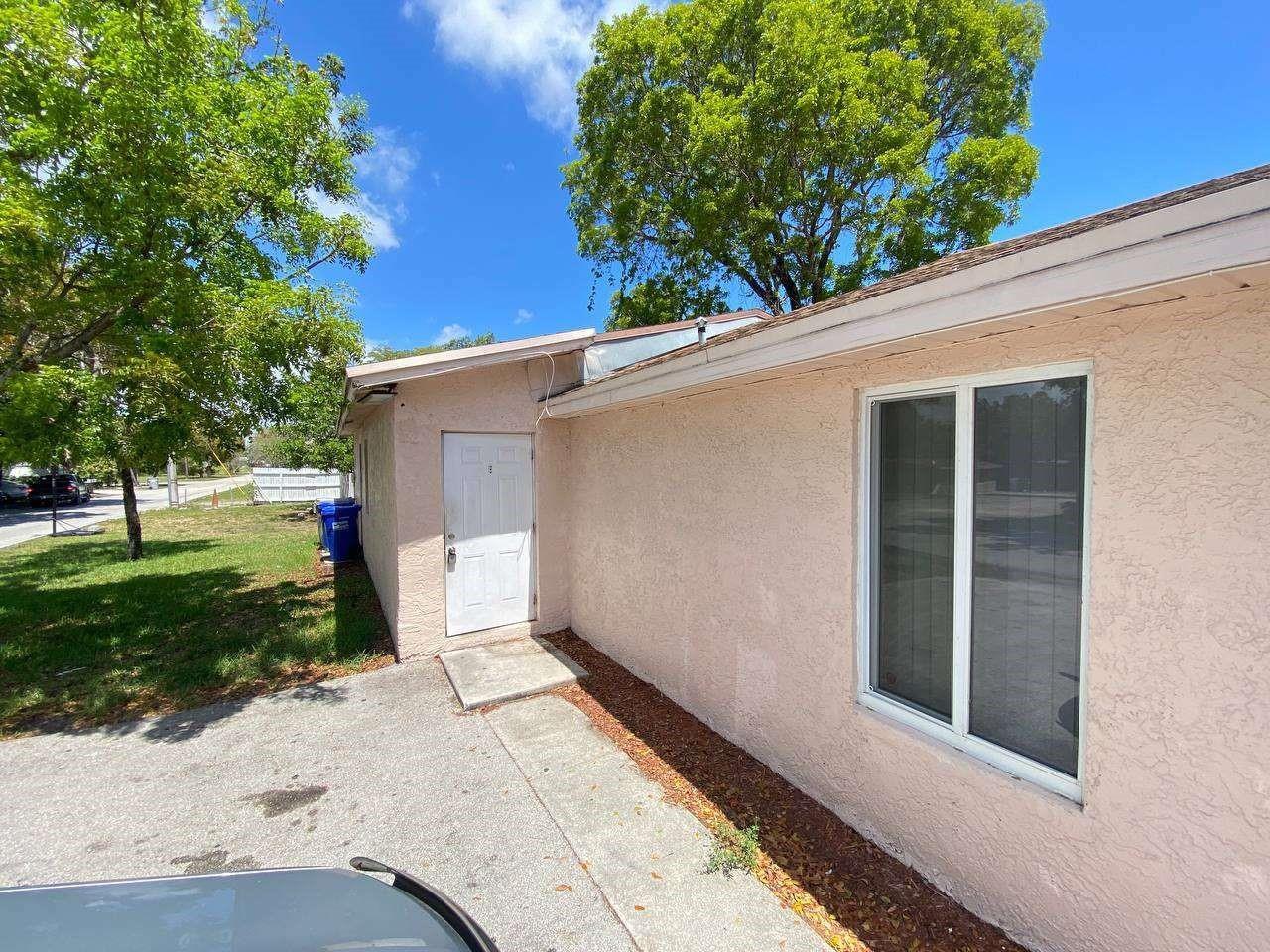 A side view of a pink stucco building with a white door and a window — 141 NW 10th Street, Pompano Beach FL 33060, POMPANO BEACH, FL