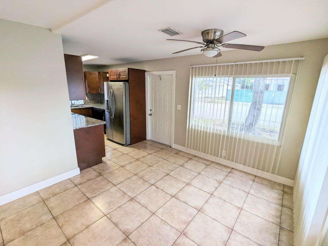 A kitchen and dining area with tile flooring, stainless steel appliances, and a ceiling fan — 141 NW 10th Street, Pompano Beach FL 33060, POMPANO BEACH, FL