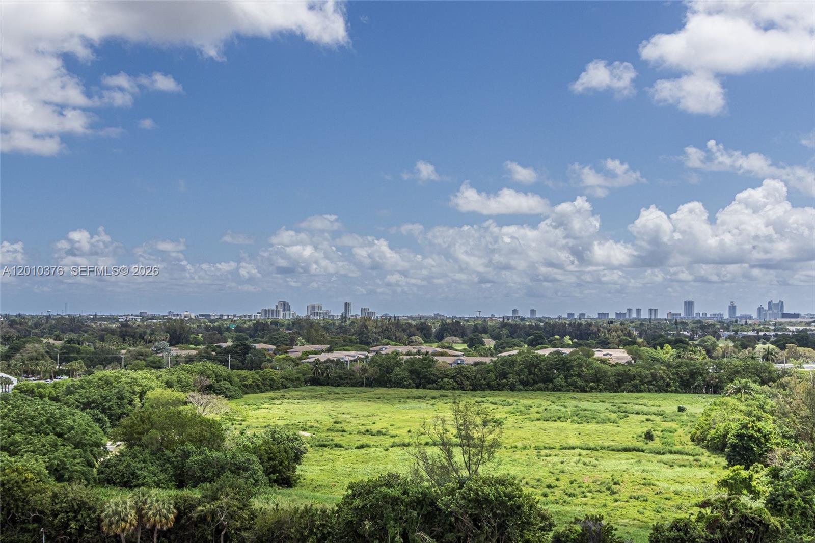 A wide-angle view shows a grassy field with trees and a distant city skyline — 3800 Hillcrest Dr # 1211, Hollywood FL 33021, HOLLYWOOD, FL