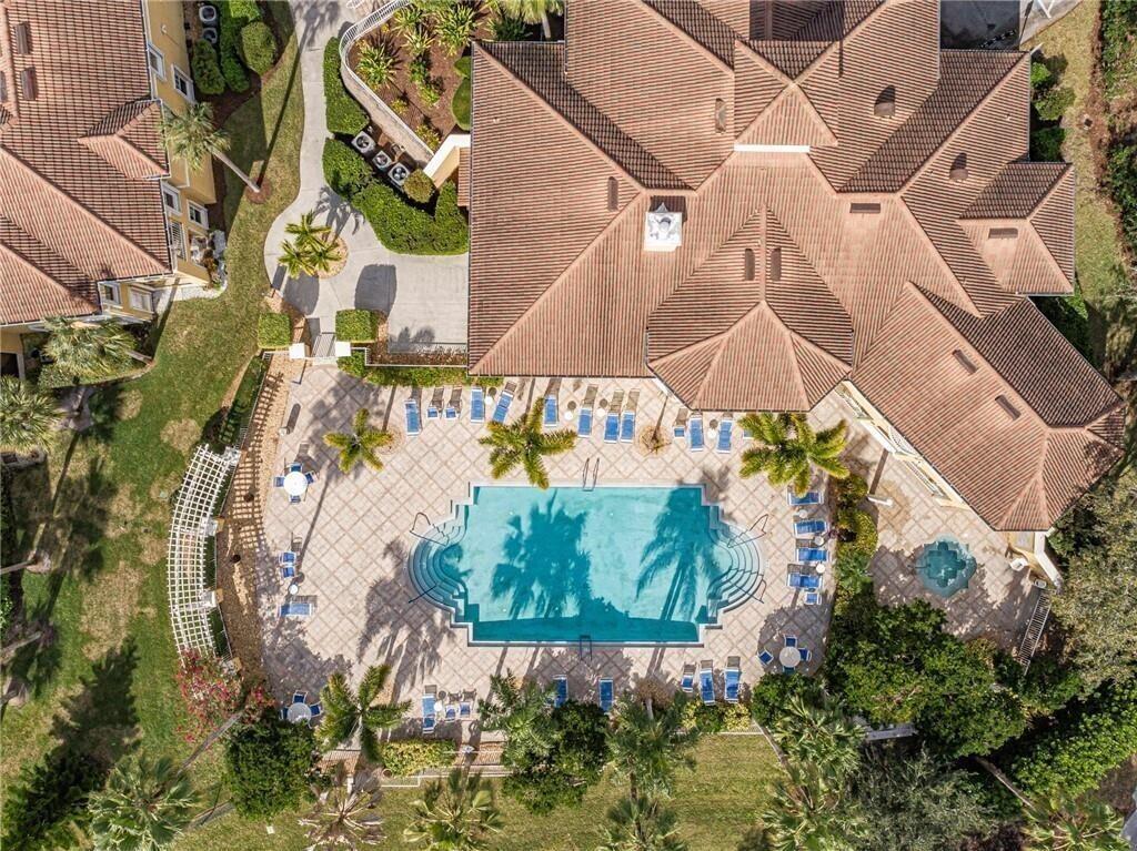 An aerial view shows a large house with a tiled roof and a swimming pool — 5095 Fairways Circle # I303, Vero Beach FL 32967, VERO BEACH, FL